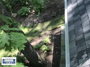 Clean GutterDome micro-mesh gutter guard on a comp-shingle family home